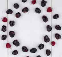 Free photo top view of blackberry with raspberries on a white surface