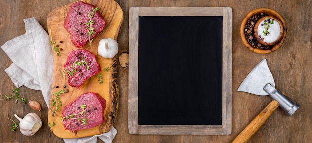 Top view of blackboard with meat and garlic