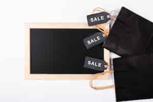 Free photo top view blackboard with shopping bags