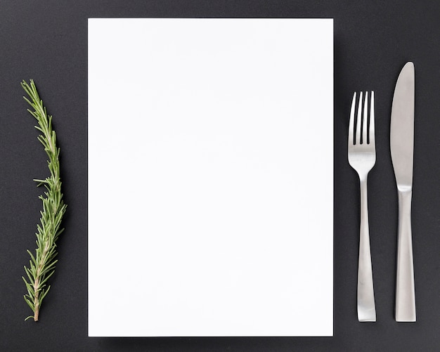 Top view of blank menu paper with pine and cutlery