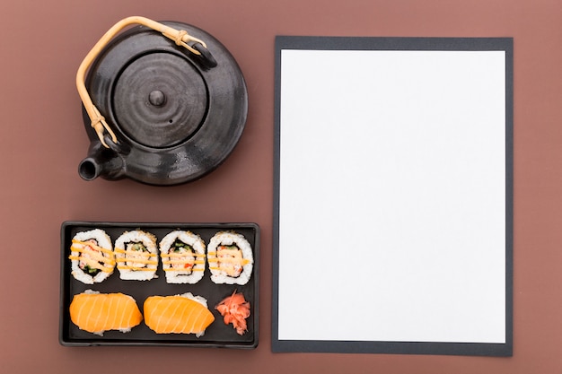 Free photo top view of blank menu paper with teapot and sushi