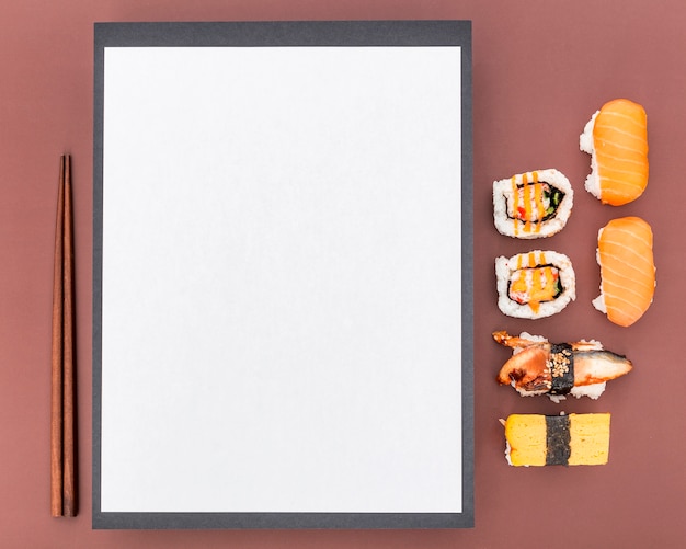 Free Photo top view of blank menu with chopsticks and sushi