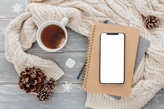 Top view blank phone on agendas with tea mug