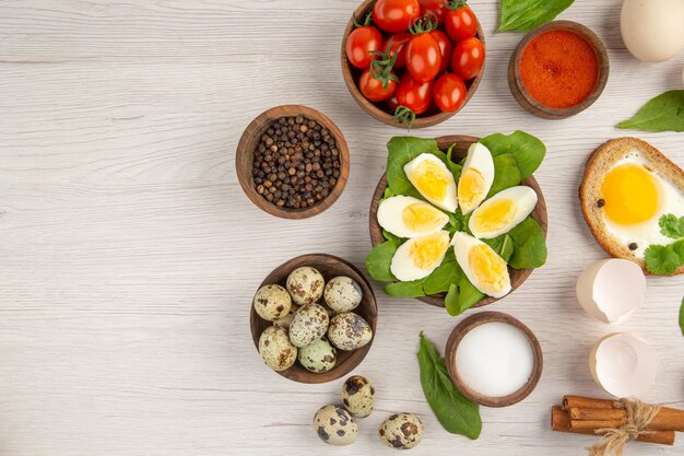 Top view boiled eggs with tomatoes and seasonings on light background photo morning meal lunch color food salad breakfast