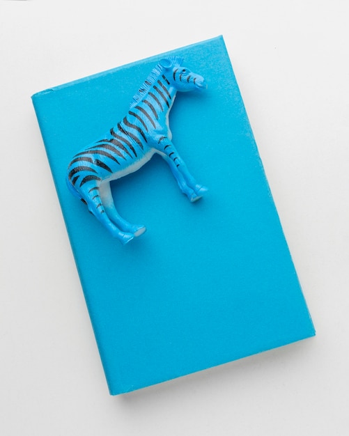 Free Photo top view of book with zebra figurine on top for animal day