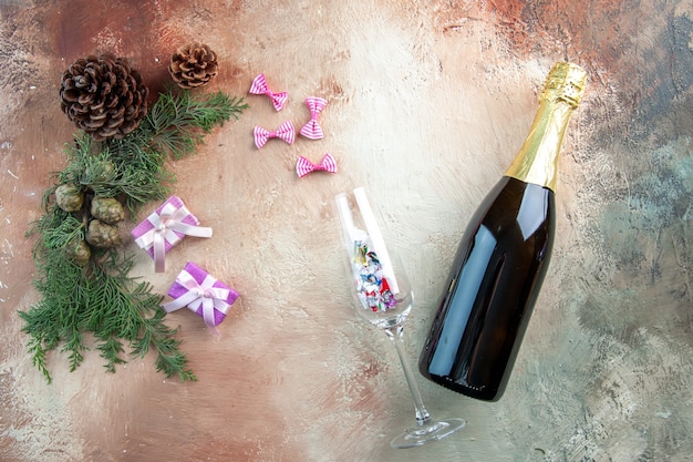 Top view bottle of champagne with little presents on light gift xmas photo new year color alcohol