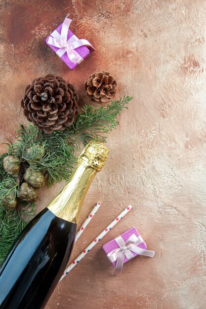 Top view bottle of champagne with little presents on a light xmas photo new year color gift alcohol