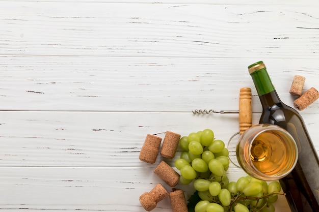 Top view bottle of wine with glass and bunch of grapes