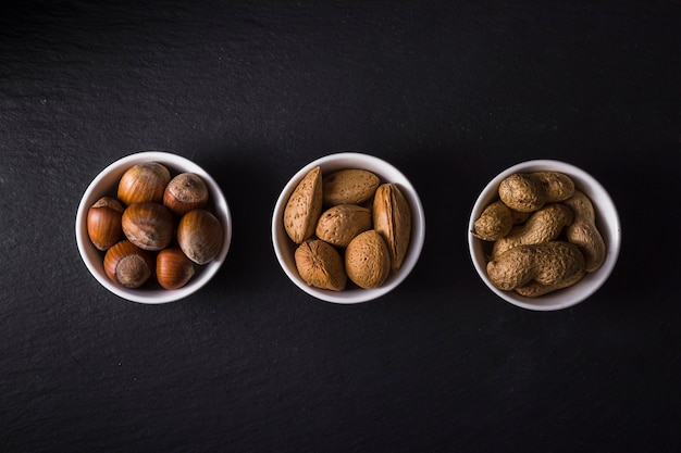 Free Photo top view bowls filled with tasty nuts