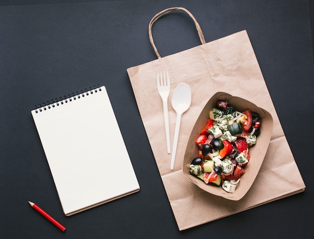 Top view box with salad on paper bag