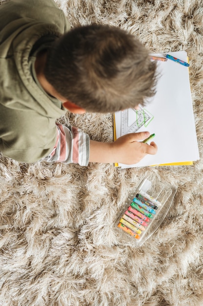 Top view of boy painting at home