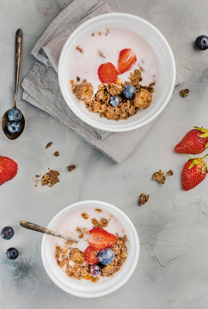 Top view breakfast bowls with granola and milk