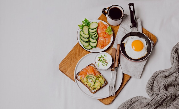 Free photo top view of breakfast sandwiches on bed with fried egg and copy space