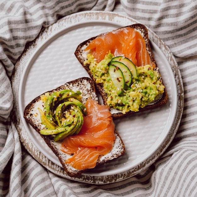 Top view of breakfast sandwiches on bed with salmon and avocado