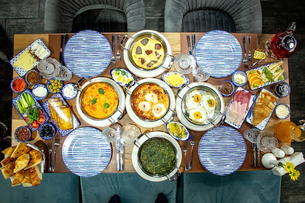 Free photo top view of breakfast table flat-lay of fried eggs with herbs tomatoes and sausages