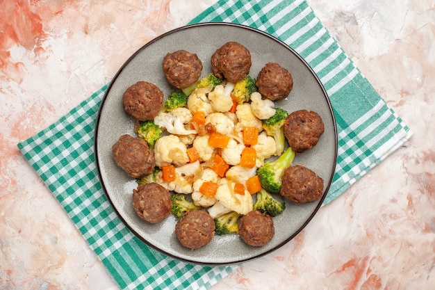 Free Photo top view broccoli and cauliflower salad and meatball on plate green and white checkered napkin on nude isolated background