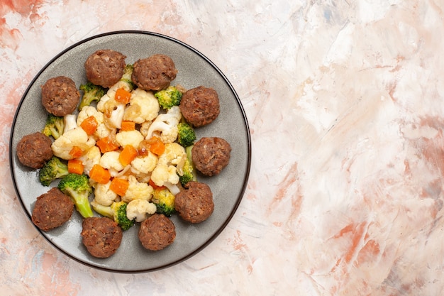 Free photo top view broccoli and cauliflower salad and meatball on plate on nude isolated surface with copy space