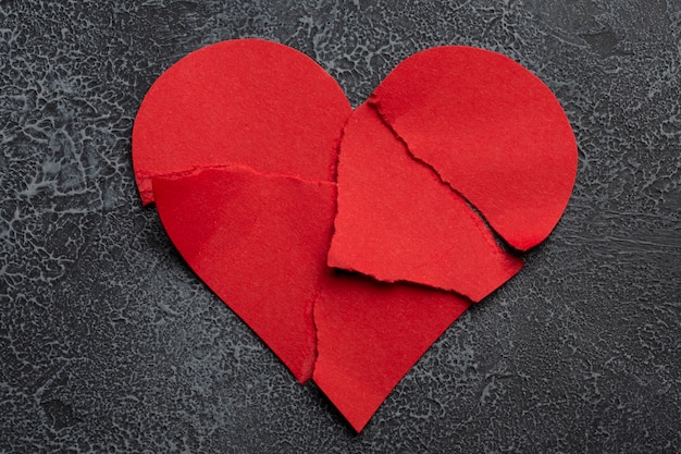 Top view broken red heart on textured background