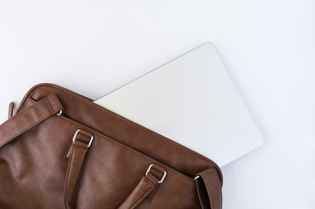 Top view of brown handbag with tablet