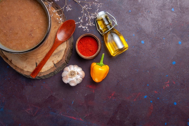 Top view brown soup with olive oil and garlic on dark surface soup vegetables meal food kitchen bean