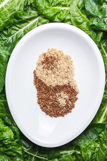 Free Photo top view of brown and white grains mixed in a white plate creating  ying and yang