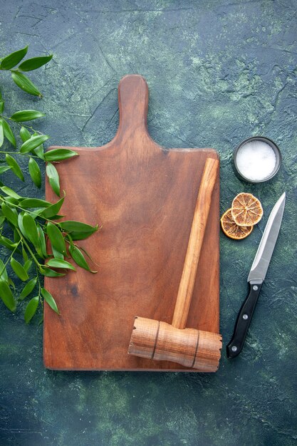 Top view brown wooden desk with hammer on the dark-blue surface color wood kitchen sharp brown cutlery tree spoon