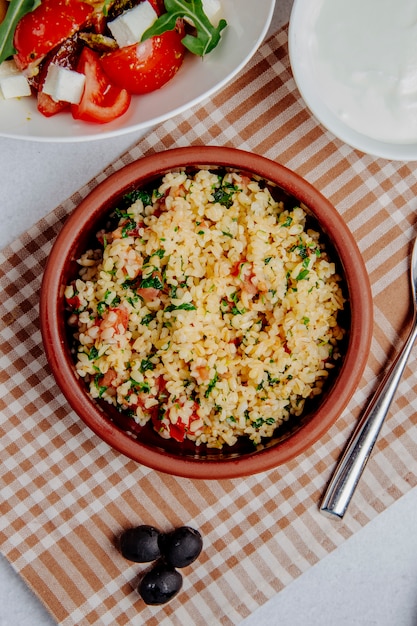 Top view of bulgur with tomatoes on the table