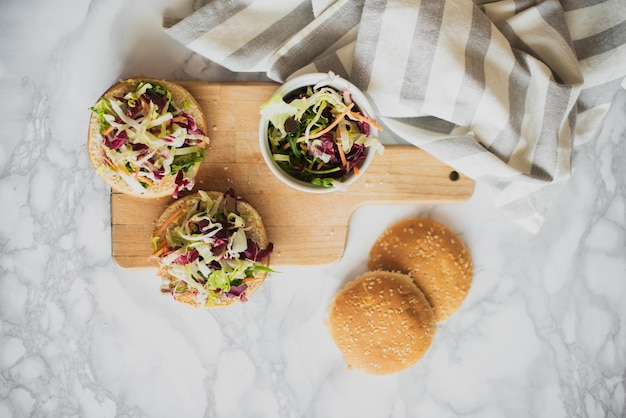 Top view buns with fresh salad on table