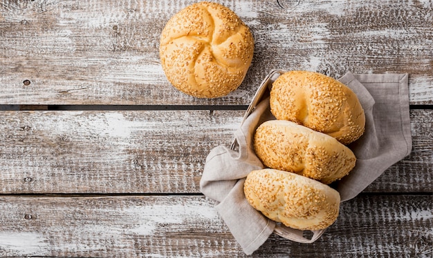 Free photo top view buns with sesame on wooden background