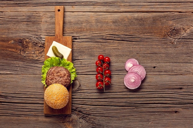 Free Photo top view burger ingredients on wooden table