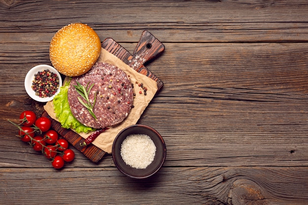 Free photo top view burger ingredients on a wooden table