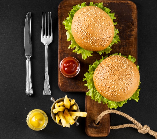 Top view burgers and fries on cutting board