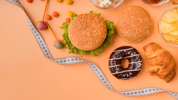 Top view burgers and snacks with tape measure