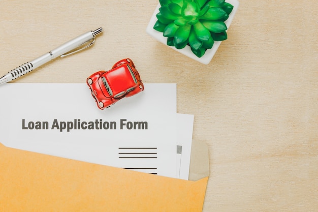 Free photo top view business office desk background.the business loan appcation form pencil  letter and car tree on wooden table background with copy space.