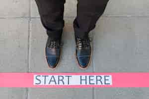 Free photo top view businessman feet with message on the floor