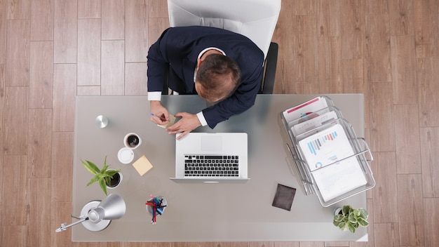 Top view of businessman writing online profit on stickey notes working at management strategy