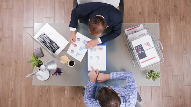 Top view of businessmen analyzing management statistics planning company strategy