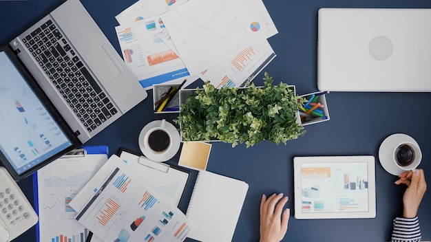 Free Photo top view of businesswoman analyzing financial graphs statistics drinking coffee