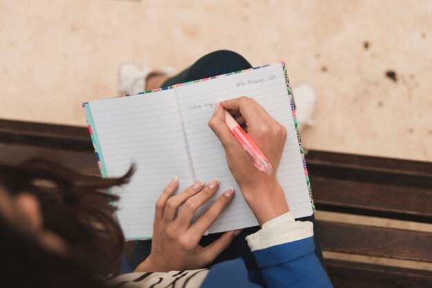 Top view of businesswoman writing in a notebook