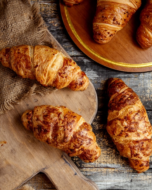 Free photo top view of butter croissants placed on wooden board