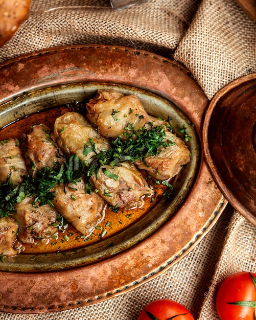 Free Photo top view cabbage rolls with herbs and tomatoes on the table