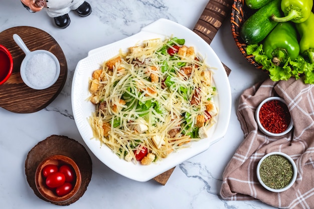 Top view caesar salad with chicken in a plate with cherry tomatoes