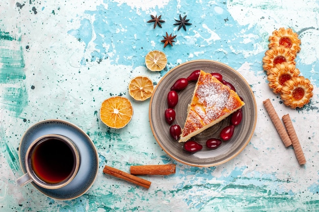 Free photo top view cake slice with cookies and cup of tea on a blue surface fruit cake bake pie biscuit sweet