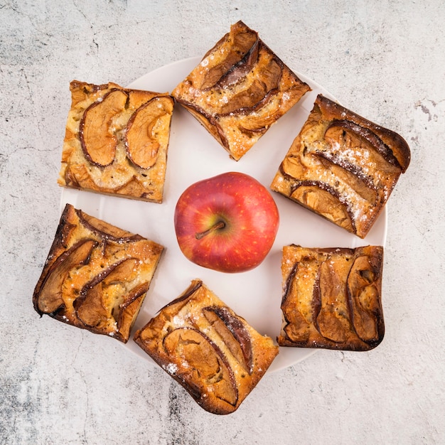 Top view cake slices and an apple on the table