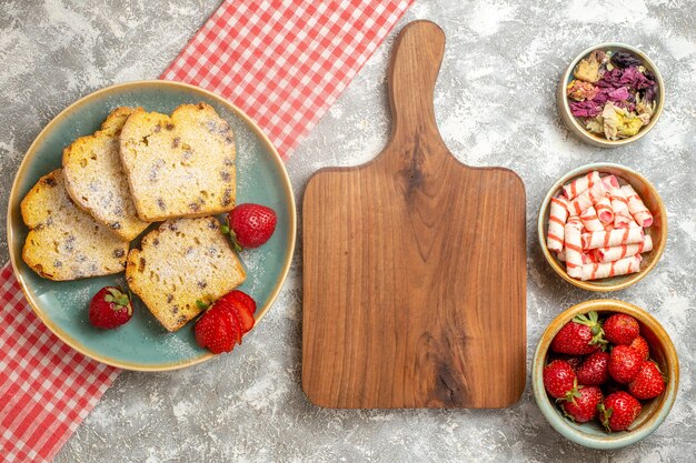 Top view cake slices with fresh strawberries on light surface sweet pie fruit