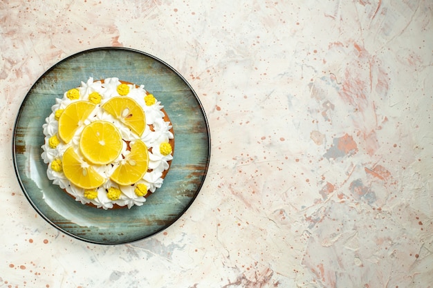 Free photo top view cake with white pastry cream and lemon slices