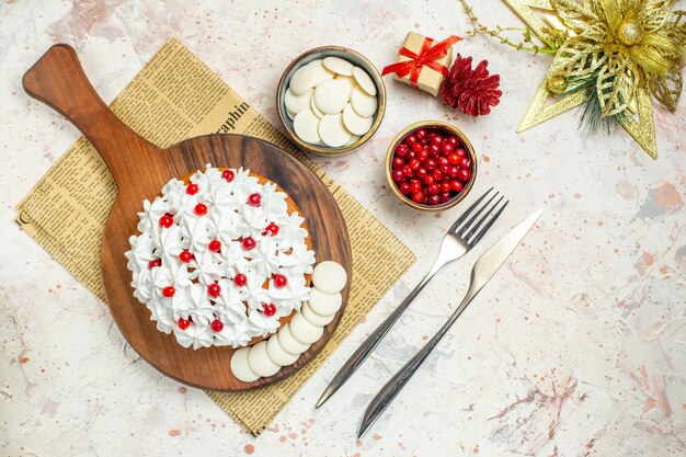 Top view cake with white pastry cream on wood board on newspaper and and xmas ornament