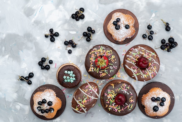 Free photo a top view cakes and donuts chocolate based with fruits and candies cake biscuit