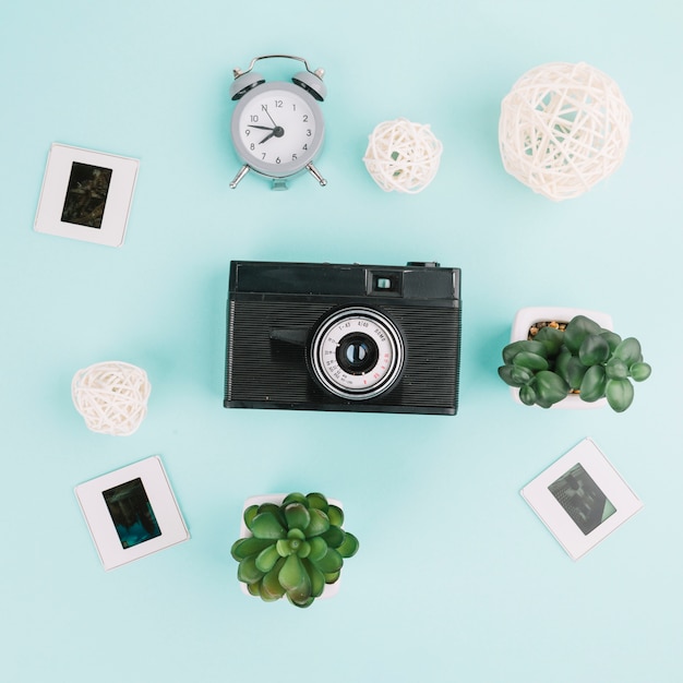 Free Photo top view camera with negatives, clock and plants