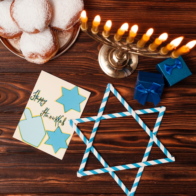 Free photo top view candleholder with doughnuts on a table